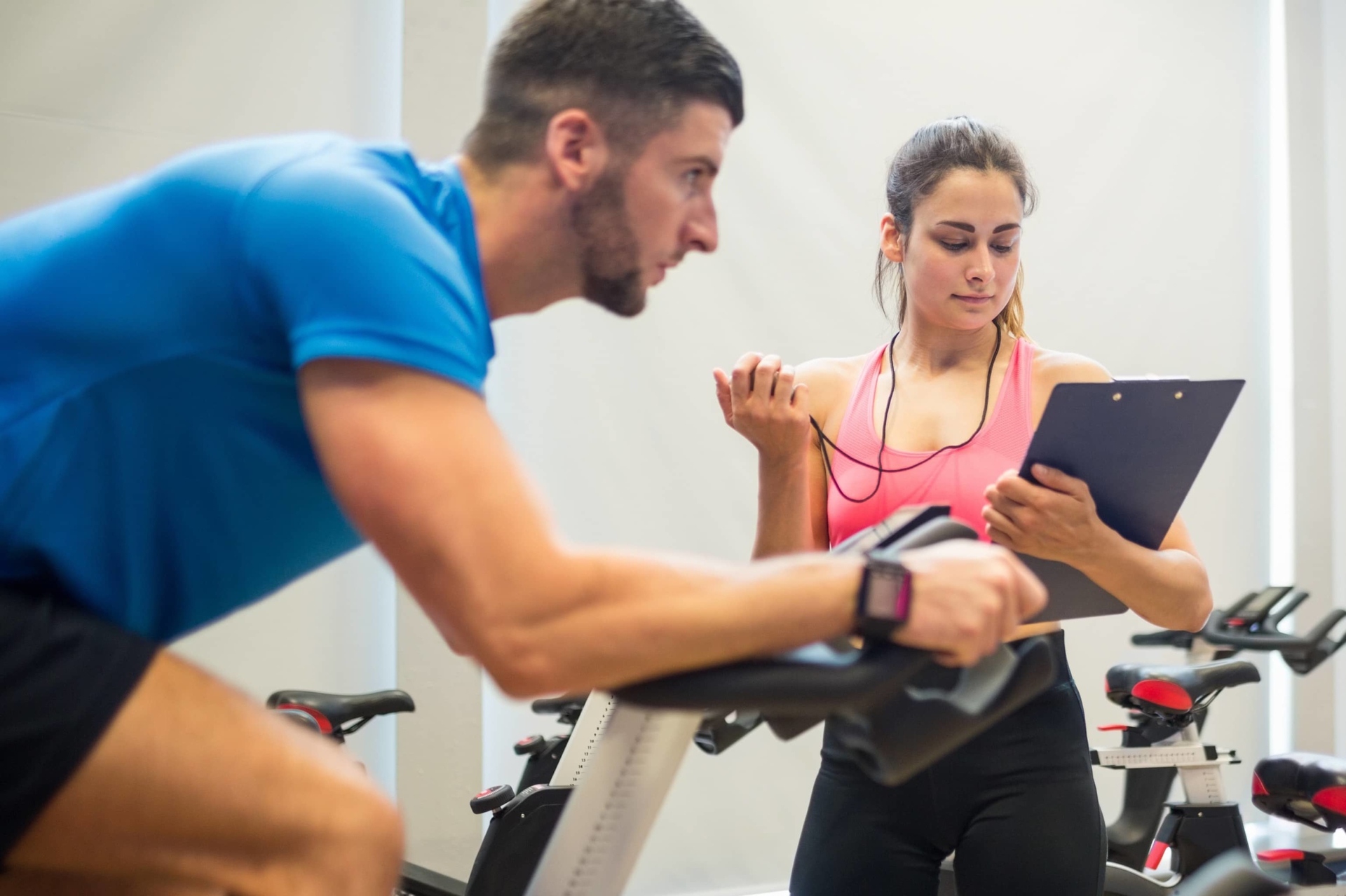 personal trainer with client on exercise bike