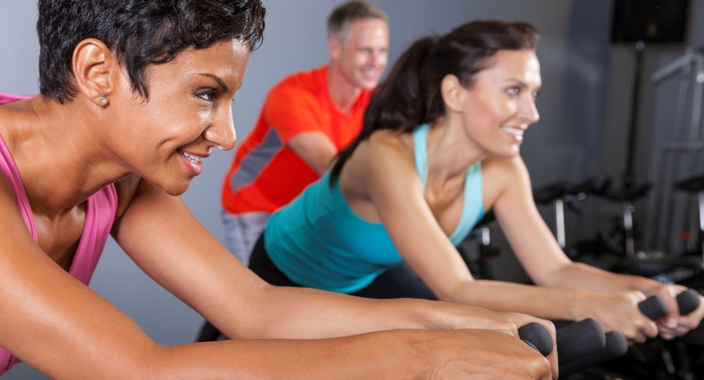 Exercise clients on spinning bikes at a gym