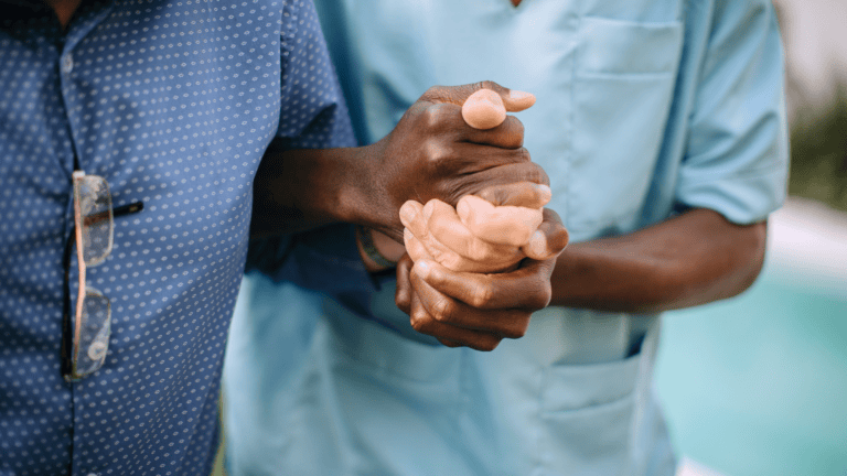 Healthcare worker in scrubs providing hand care to patient