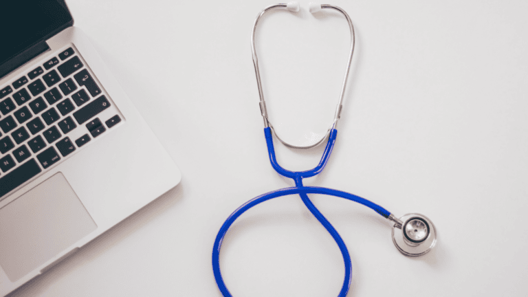 A stethoscope next to a laptop