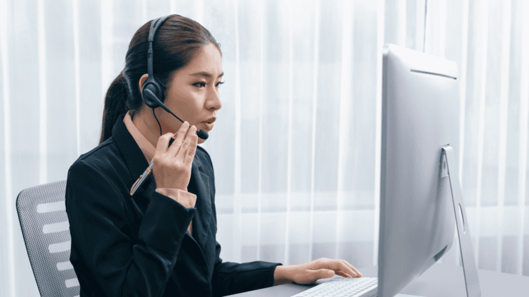 A person at a computer with a headset on