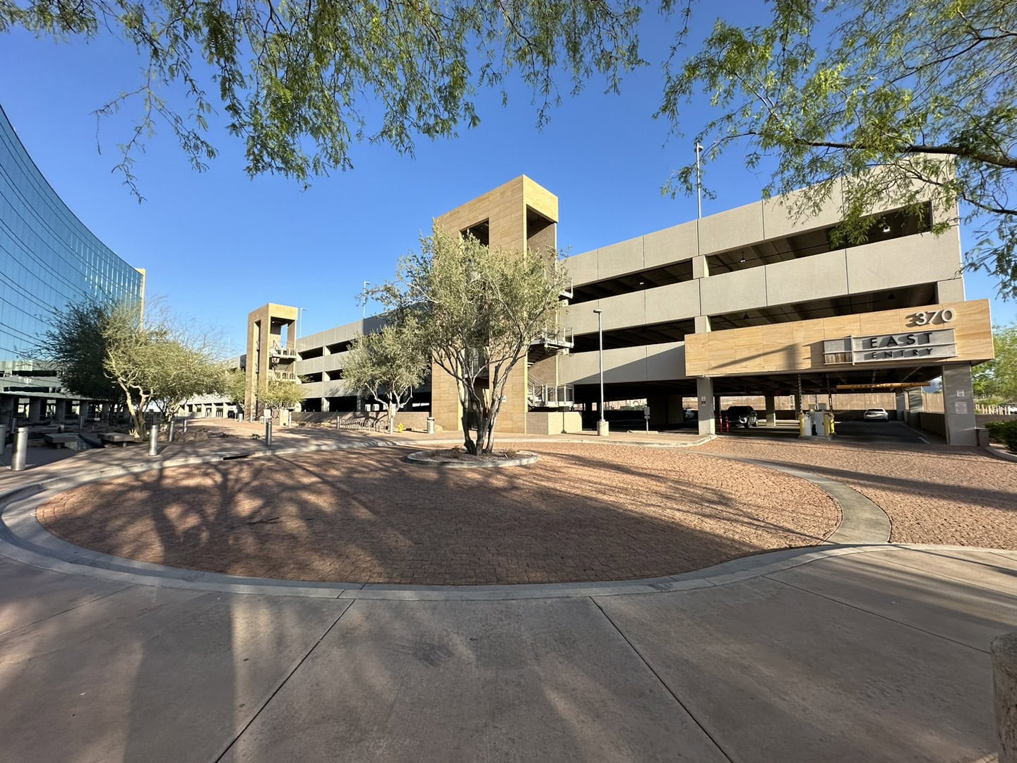 Multi-level parking garage with trees on a sunny day.